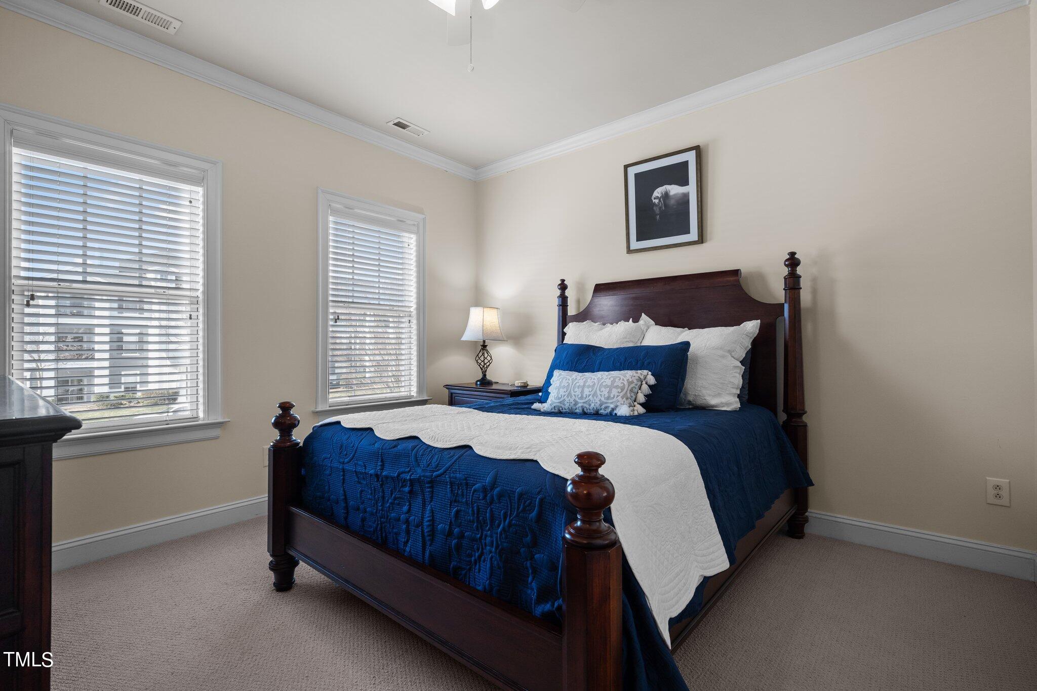 7765 Courtney Estates Drive Raleigh, NC 27617 - Photo 19 of 37 a bedroom with a bed and window