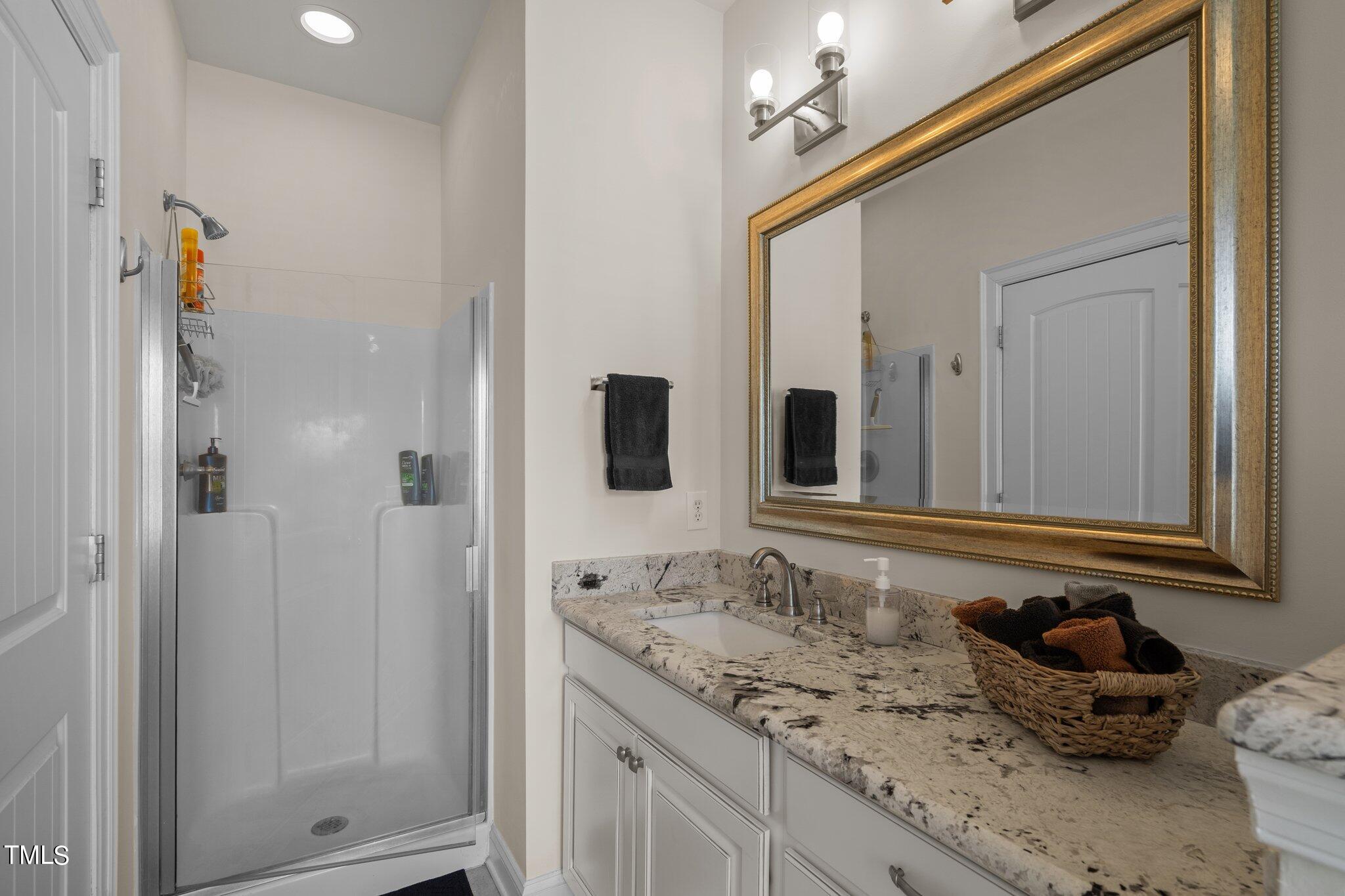 7765 Courtney Estates Drive Raleigh, NC 27617 - Photo 21 of 37 a bathroom with a granite countertop sink and a mirror