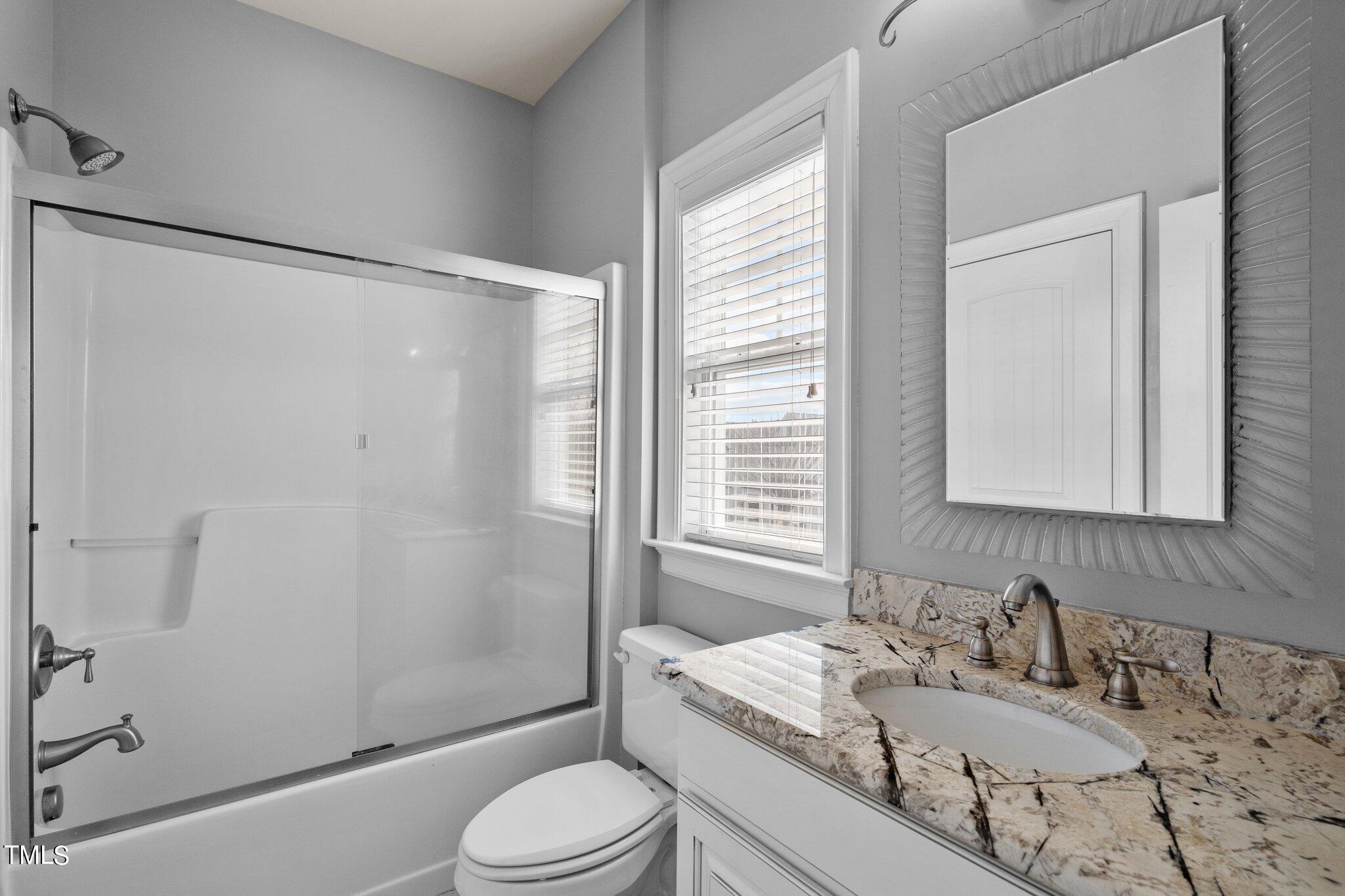 7765 Courtney Estates Drive Raleigh, NC 27617 - Photo 23 of 37 a bathroom with a granite countertop sink toilet and shower