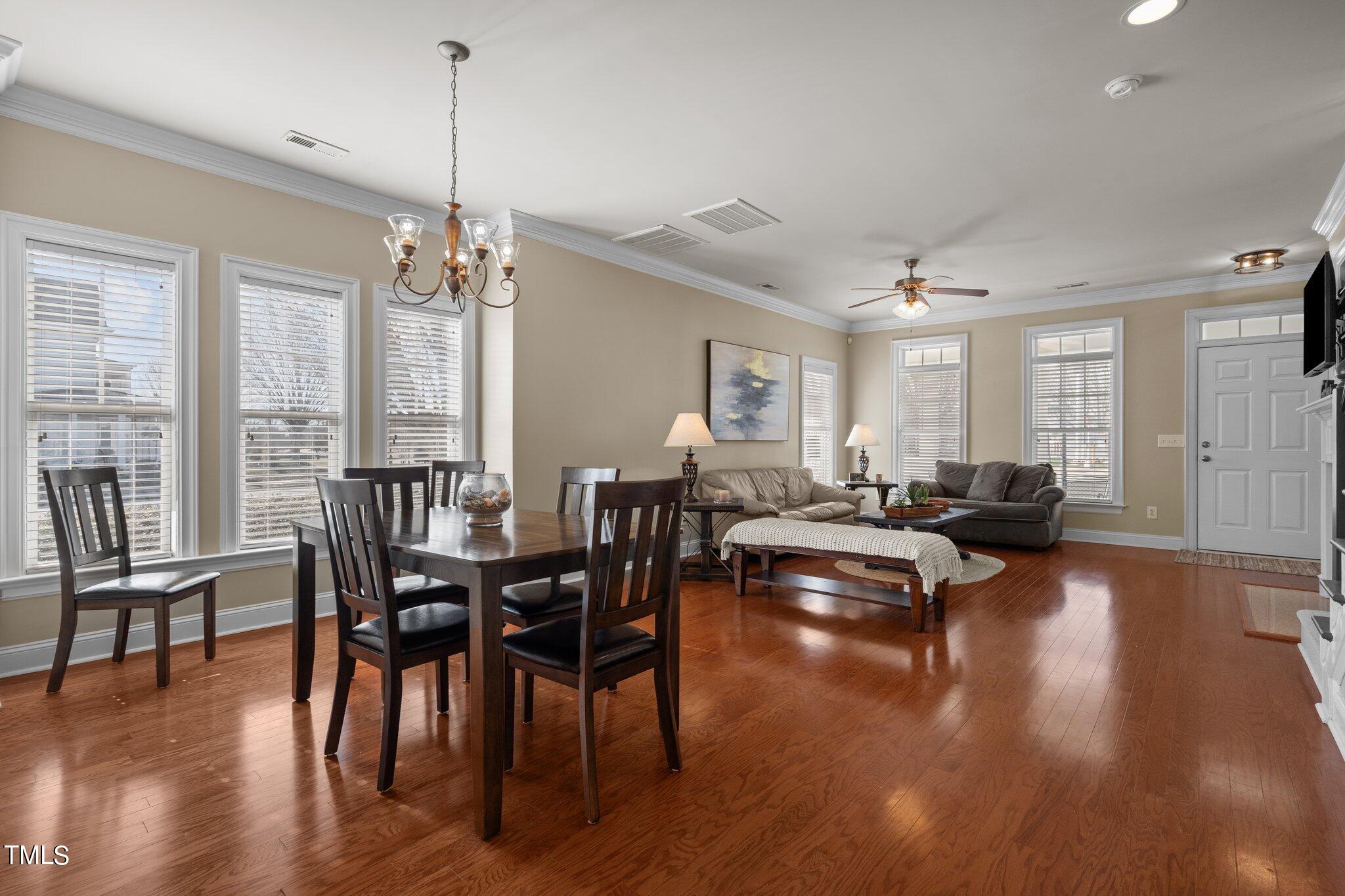 7765 Courtney Estates Drive Raleigh, NC 27617 - Photo 9 of 37 a view of a dining room and livingroom with furniture wooden floor a chandelier