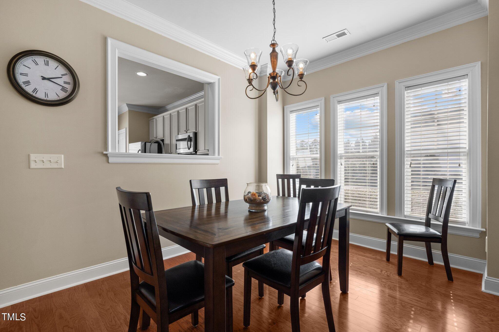 7765 Courtney Estates Drive Raleigh, NC 27617 - Photo 10 of 37 a view of a dining room with furniture window and wooden floor