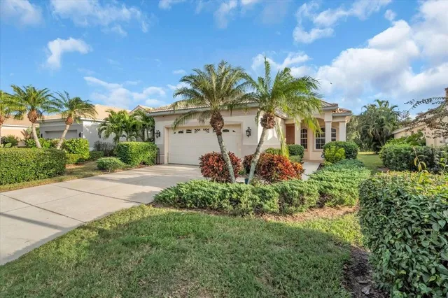 a front view of a house with a yard and potted plants
