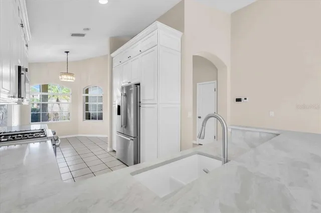 a kitchen with a refrigerator sink and cabinets