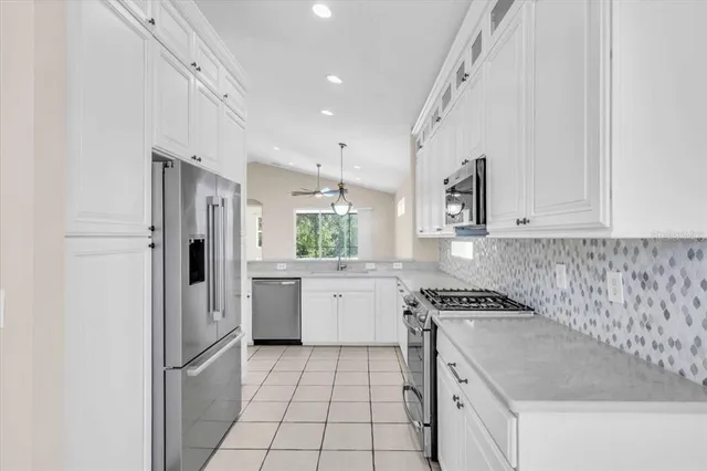 a kitchen with granite countertop white cabinets and white appliances