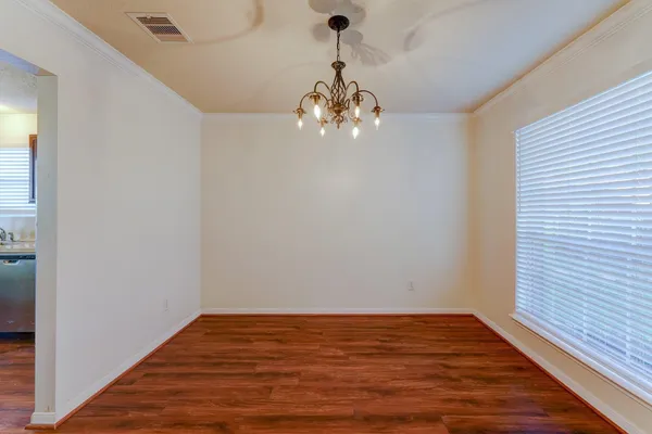 a view of a room with wooden floor and chandelier