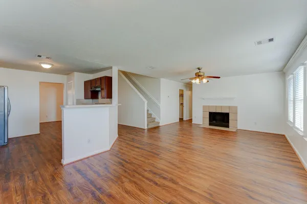 a view of empty room with wooden floor and fireplace