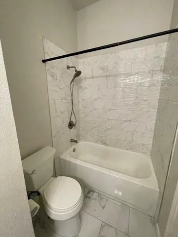 a bathroom with a toilet and a bath tub