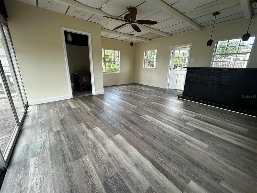 18129 Crawley Road Odessa, FL 33556 - Photo 20 of 37 an empty room with wooden floor a ceiling fan and windows