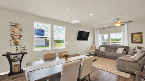 a living room with furniture a flat screen tv and a window