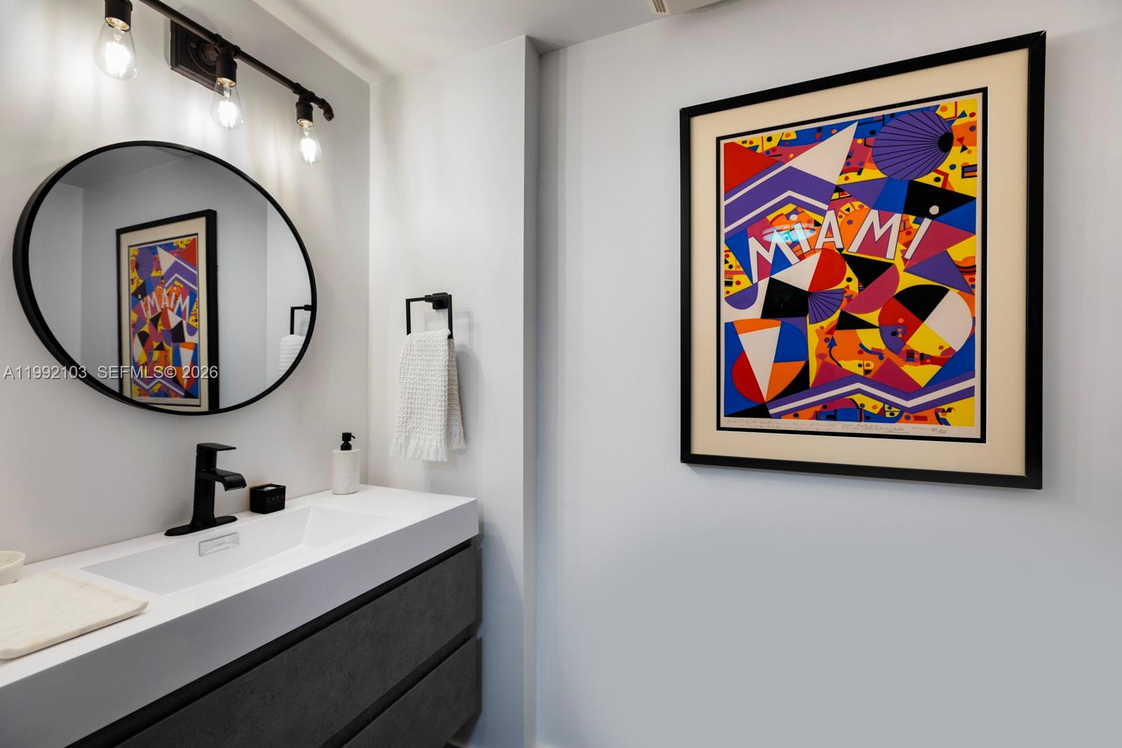 3339 Virginia Street, Unit 311 Miami, FL 33133 - Photo 11 of 16 a bathroom with a sink and a mirror