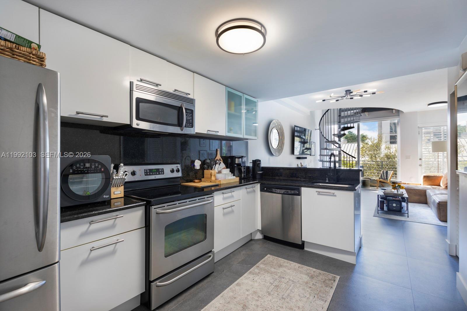 3339 Virginia Street, Unit 311 Miami, FL 33133 - Photo 8 of 16 a kitchen with stainless steel appliances granite countertop a stove and cabinets