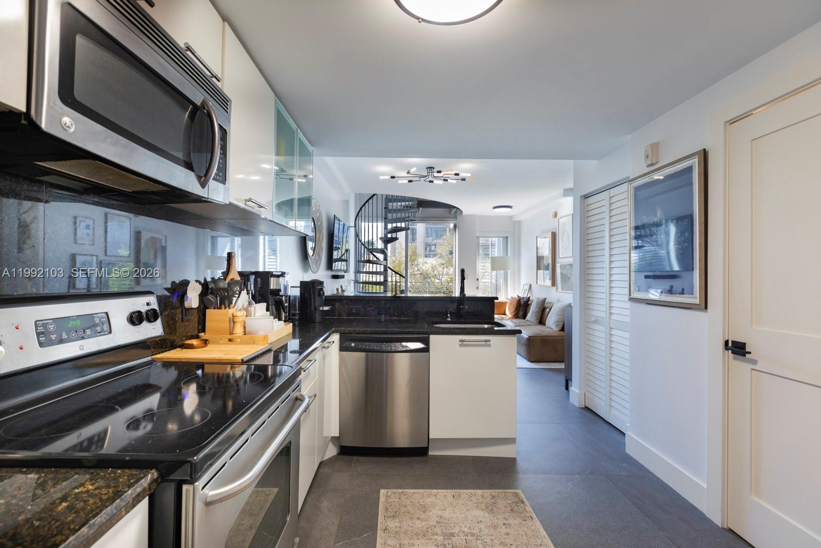 3339 Virginia Street, Unit 311 Miami, FL 33133 - Photo 9 of 16 a kitchen with stainless steel appliances a stove a sink dishwasher and cabinets with wooden floor