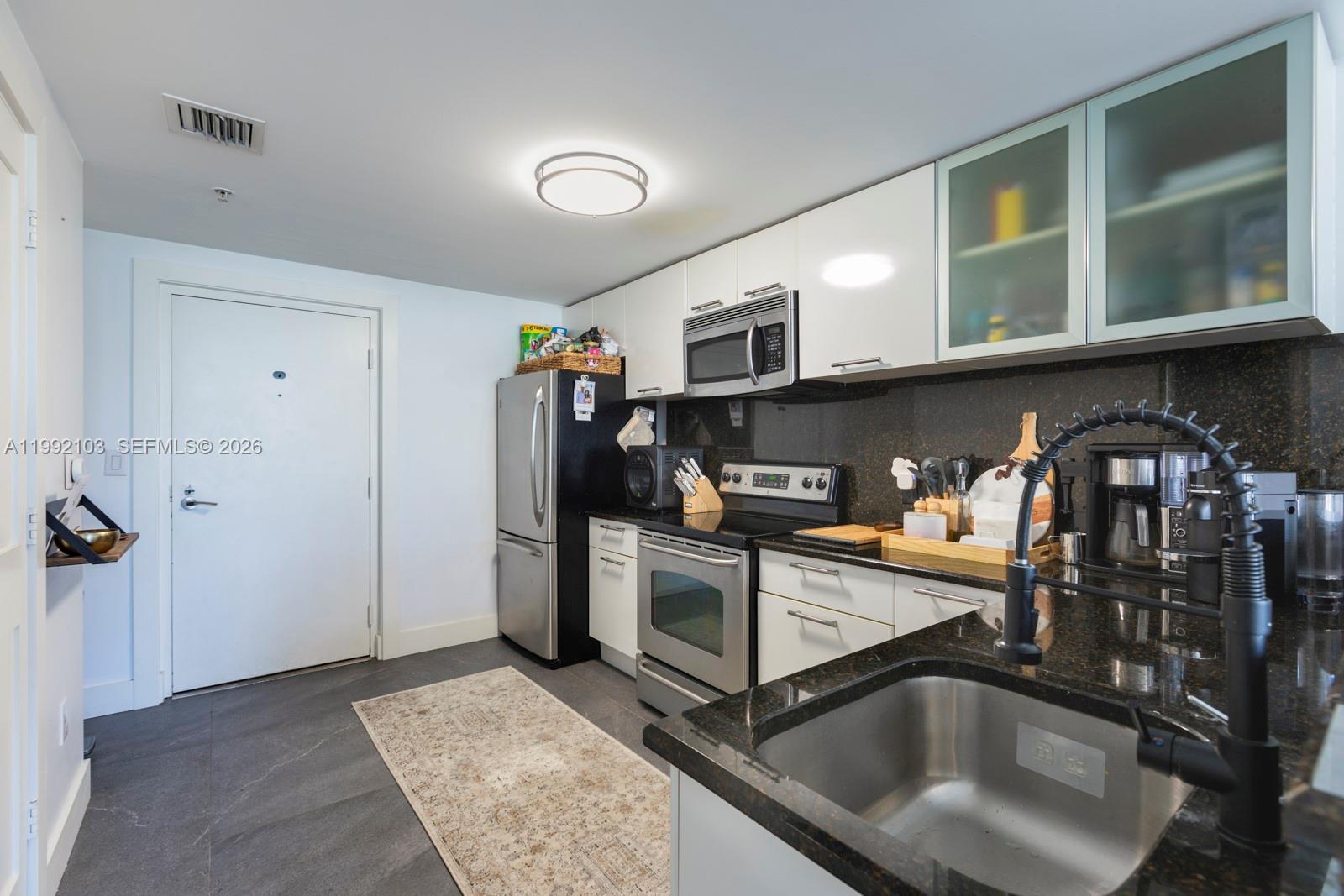 3339 Virginia Street, Unit 311 Miami, FL 33133 - Photo 10 of 16 a kitchen that has a sink and cabinets