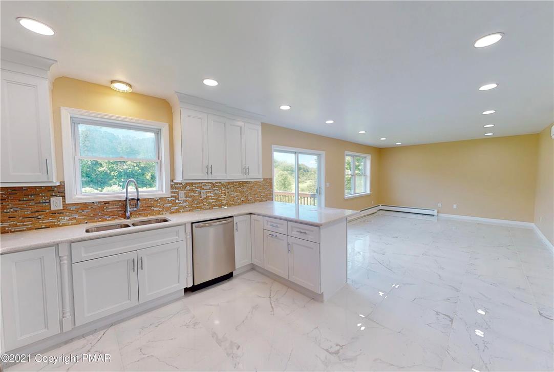 1110 Misty Ridge East Stroudsburg, PA 18302 - Photo 15 of 43 A well-lit kitchen with sleek appliances seamlessly flows into a spacious living area, offering bright views of the outdoors.