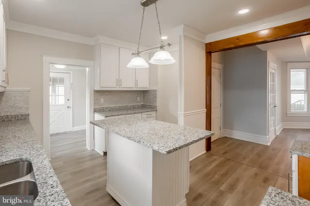 a kitchen with kitchen island granite countertop a stove a sink and a refrigerator