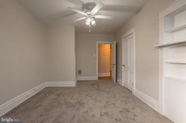 an empty room with fan and windows