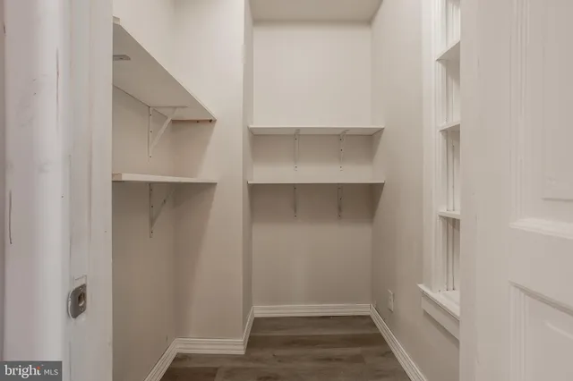 a view of walk in closet with empty racks