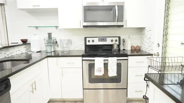 a kitchen with stainless steel appliances granite countertop a sink and a stove