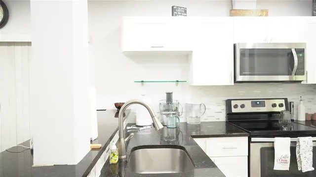 a kitchen with a sink a microwave and cabinets