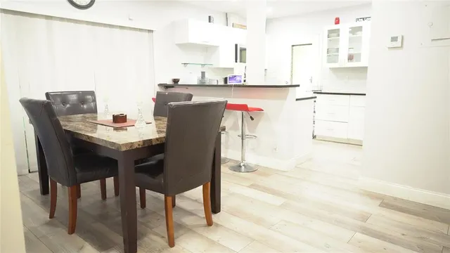 a dining table chairs and a refrigerator in a kitchen