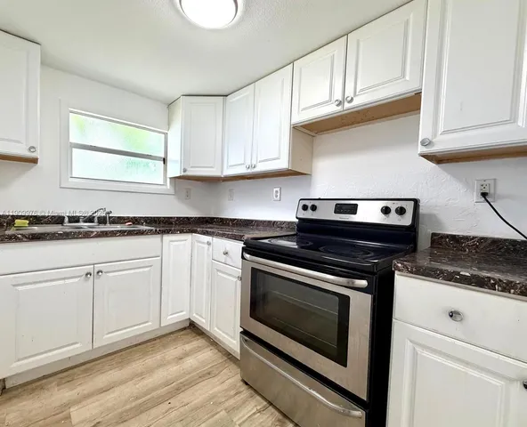 a kitchen with granite countertop cabinets and steel stainless steel appliances