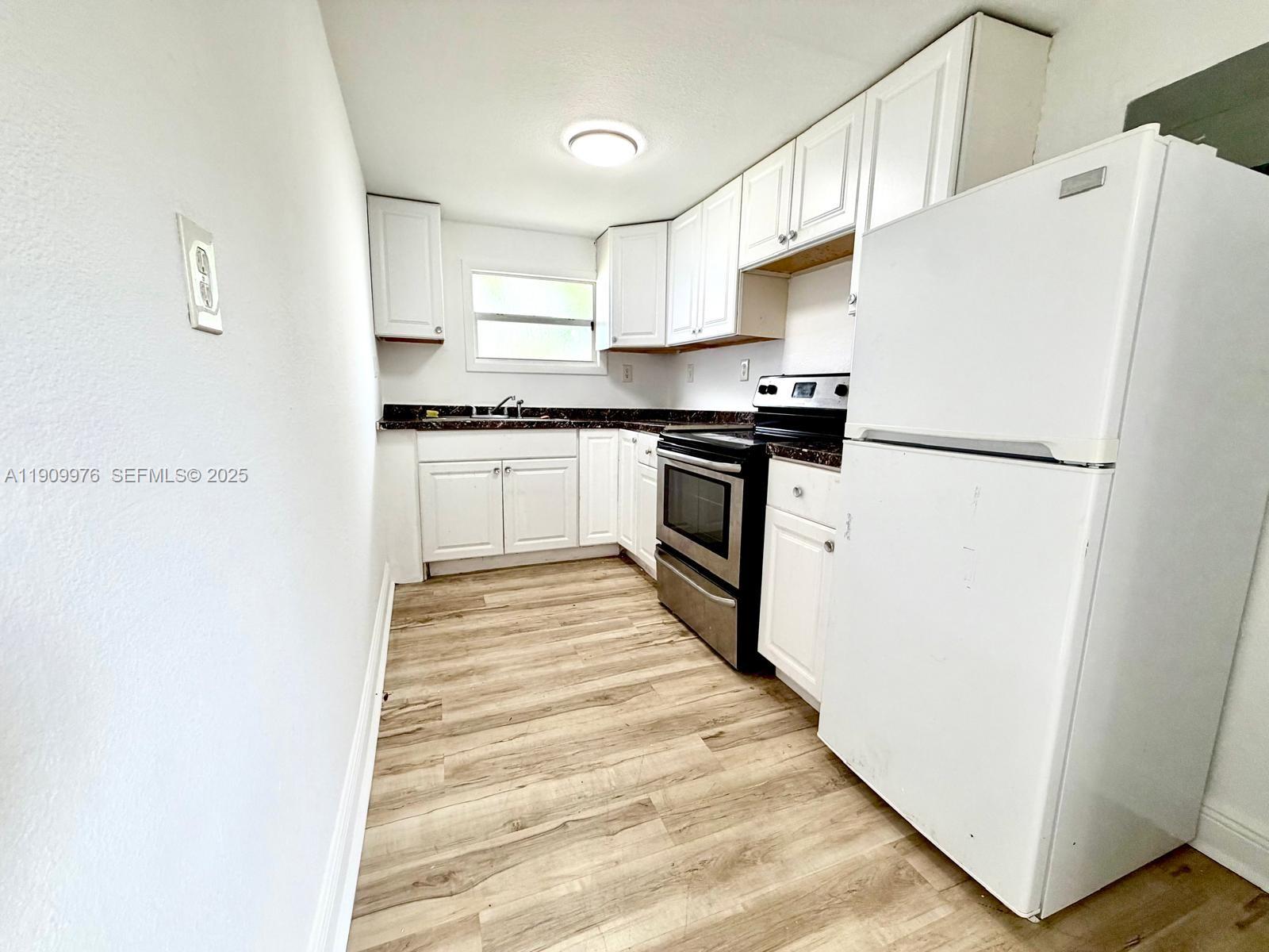1060 Northwest 116th Street, Unit 3 Miami, FL 33168 - Photo 2 of 9 a white refrigerator freezer sitting inside of a kitchen