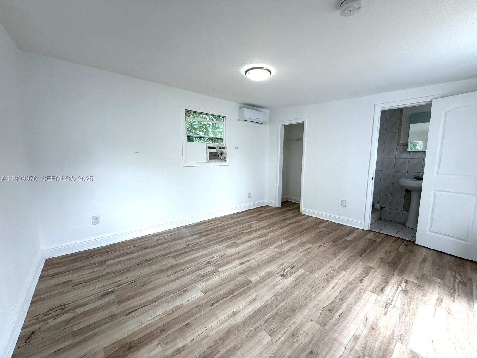 1060 Northwest 116th Street, Unit 3 Miami, FL 33168 - Photo 4 of 9 a view of empty room with wooden floor