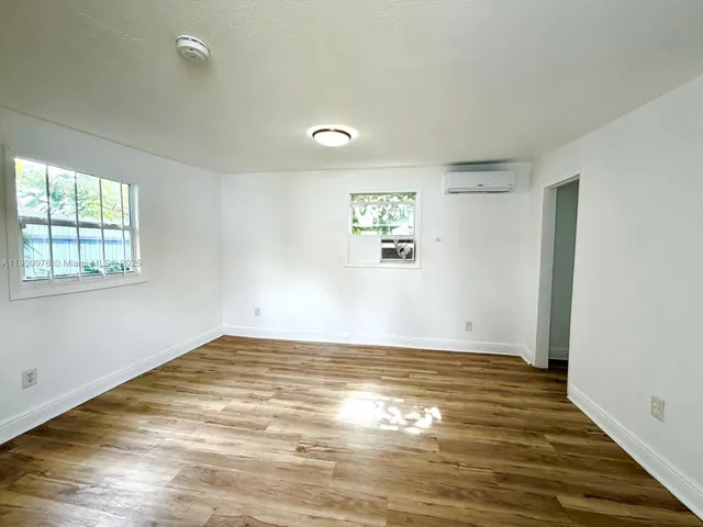a view of a room with wooden floor and window