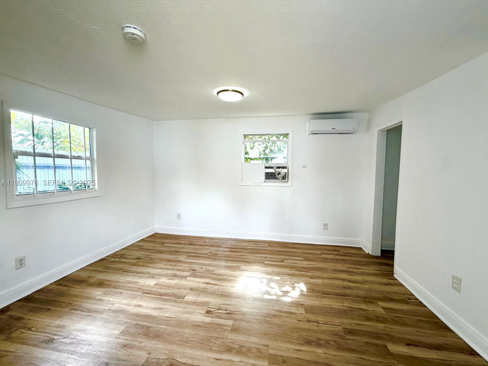 1060 Northwest 116th Street, Unit 3 Miami, FL 33168 - Photo 9 of 9 a view of empty room with wooden floor and fan