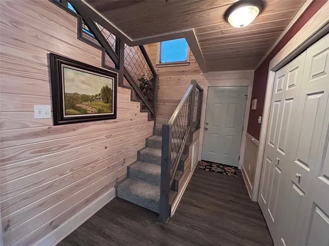 a view of a hallway with wooden floor and staircase