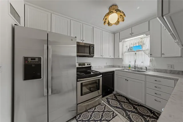 a kitchen with stainless steel appliances granite countertop a stove a refrigerator and a sink