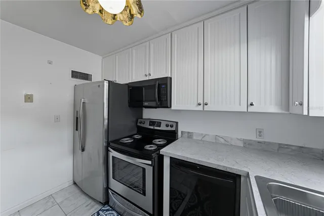 a kitchen with stainless steel appliances a stove a microwave and a refrigerator