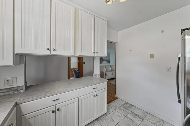 a kitchen with granite countertop white cabinets and stainless steel appliances