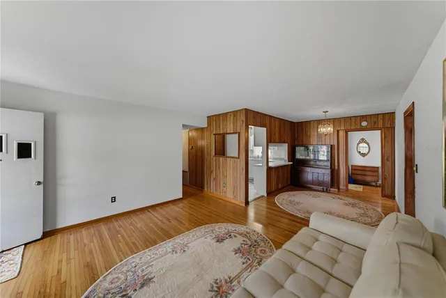 a spacious bedroom with a bed and wooden floor