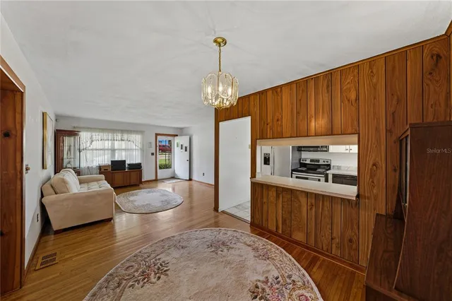 a kitchen with stainless steel appliances granite countertop a refrigerator a stove and white cabinets with wooden floor