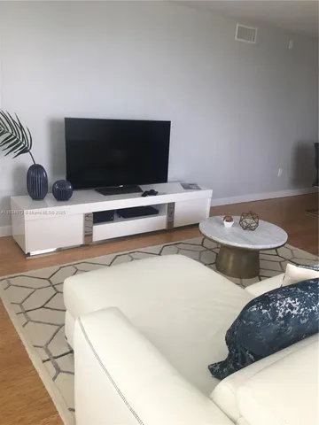 a living room with two couches and a flat screen tv