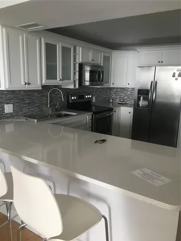 a kitchen with stainless steel appliances granite countertop a sink a stove and microwave