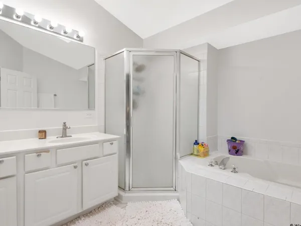 a bathroom with a sink vanity tub and shower