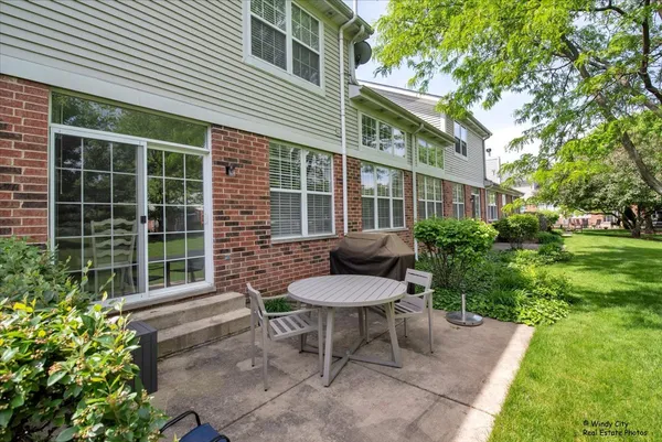 a view of a chair and table in backyard of the house