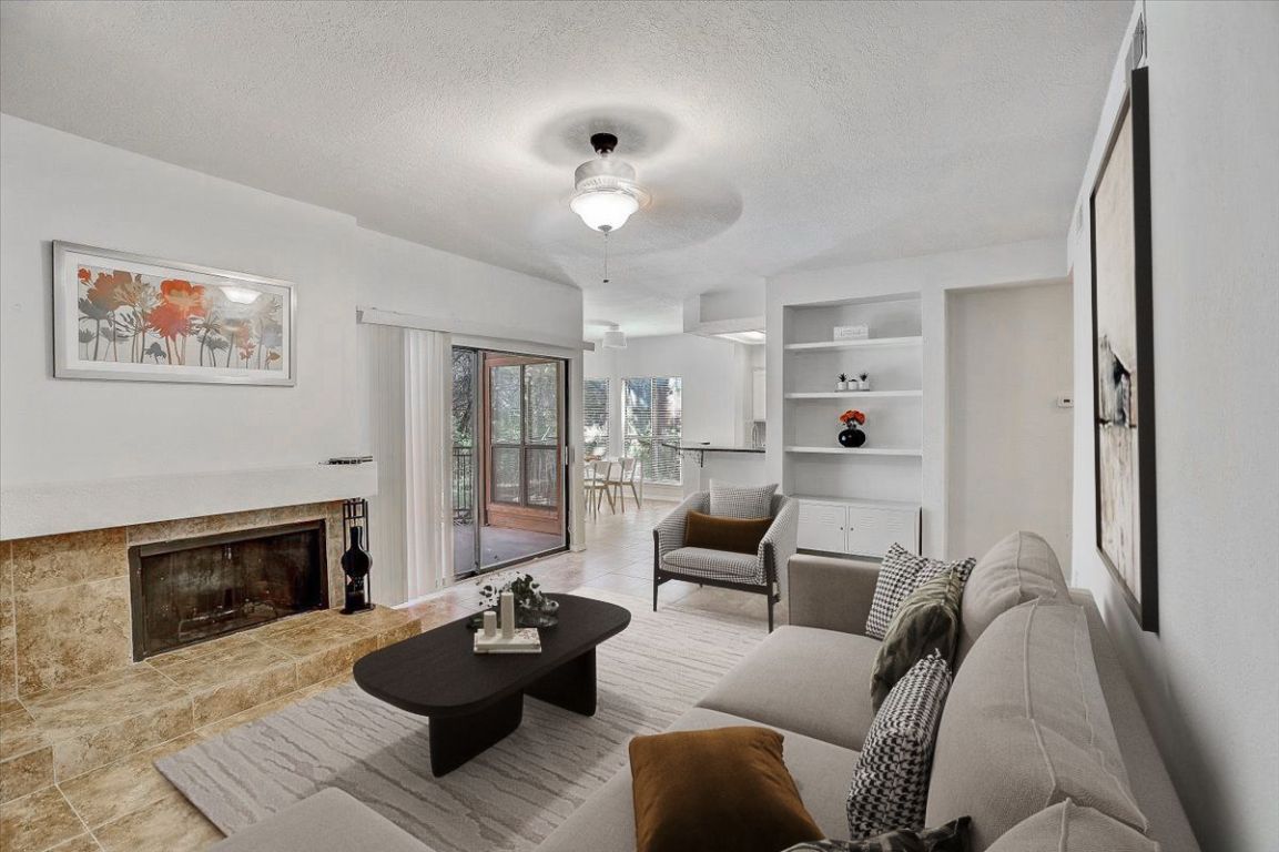 4711 Spicewood Springs Road, Unit 2112 Austin, TX 78759 - Photo 3 of 29 a living room with furniture and a fireplace