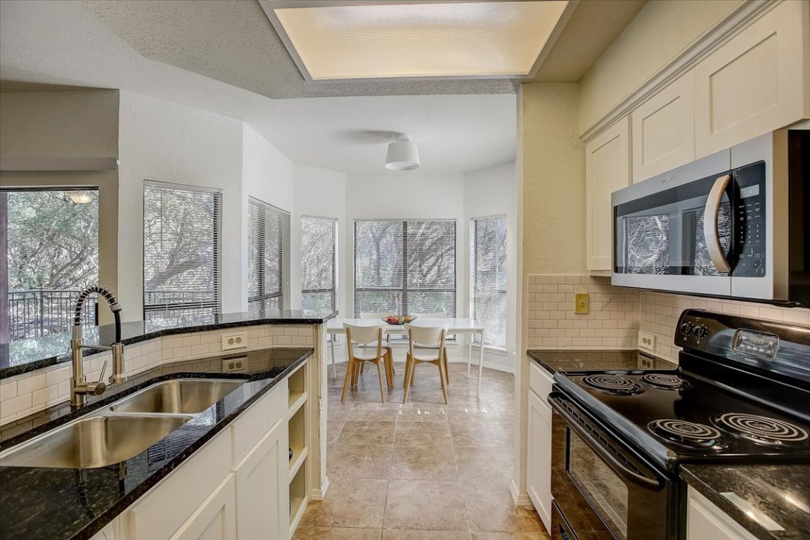 4711 Spicewood Springs Road, Unit 2112 Austin, TX 78759 - Photo 8 of 29 a kitchen with a stove sink and cabinets
