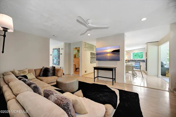 a living room with furniture a ceiling fan and a flat screen tv