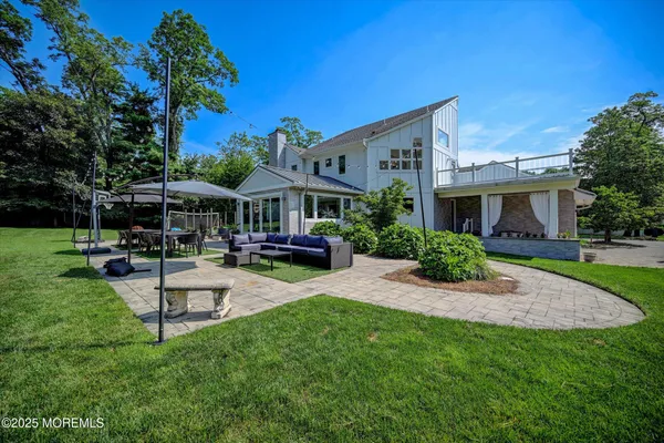 a view of a house with backyard sitting area and swimming pool