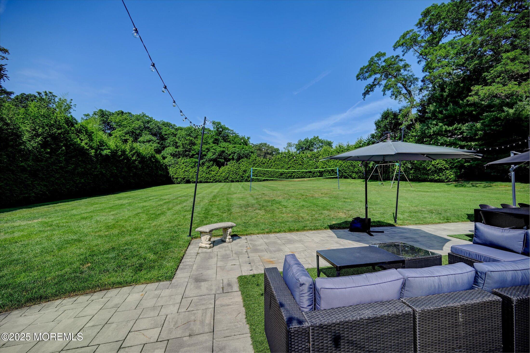 3 Woods Road West Long Branch, NJ 07764 - Photo 36 of 46 a view of a patio with chairs under an umbrella