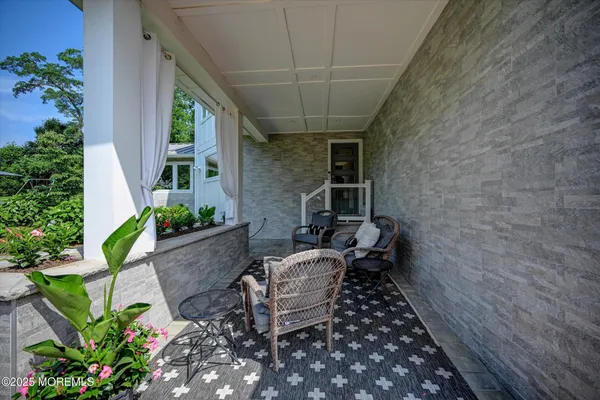 a view of a patio with chairs and potted plants