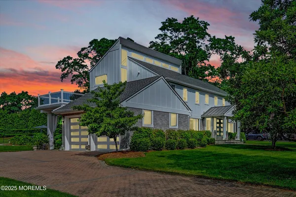 a front view of a house with a garden and trees