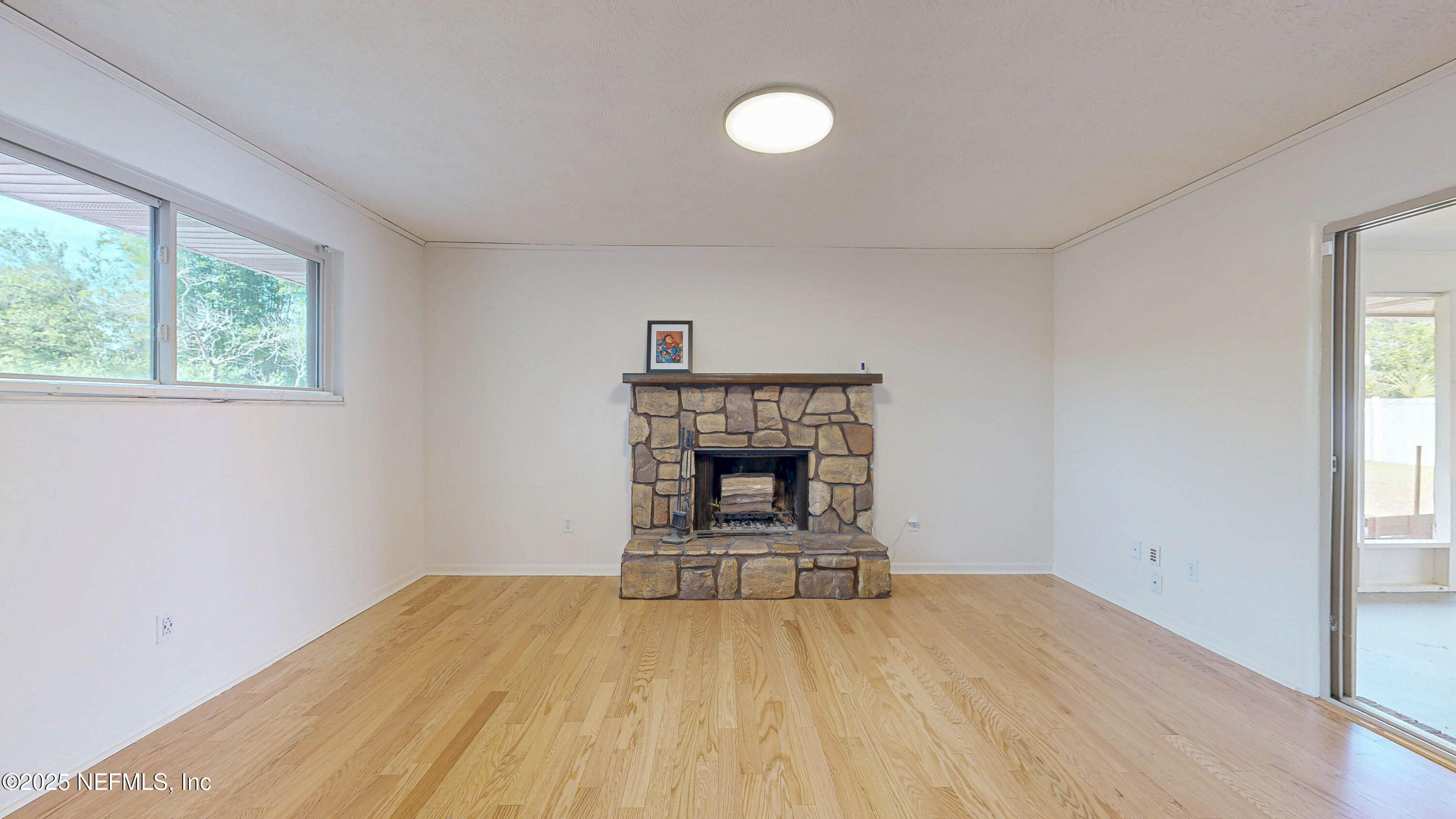 2474 Summer Tree Road East Jacksonville, FL 32246 - Photo 4 of 42 a view of empty room with wooden floor and fireplace