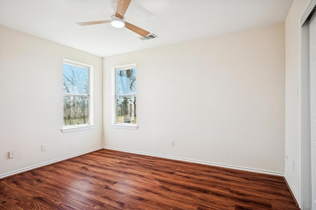 112 Sebastian Lane Josephine, TX 75173 - Photo 11 of 15 an empty room with wooden floor fan and windows
