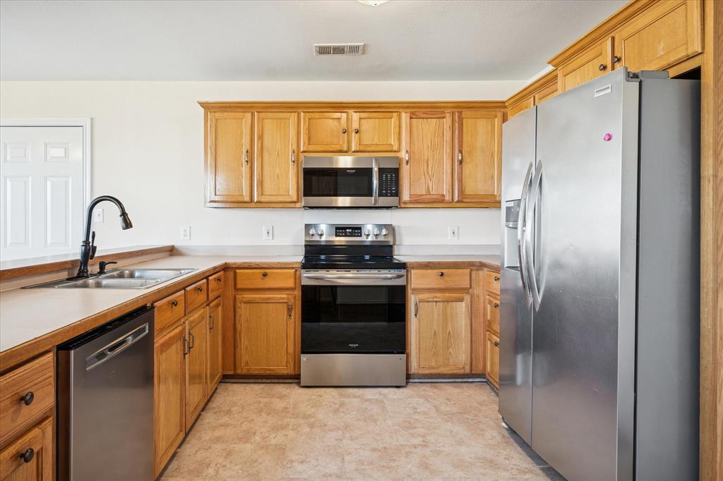 112 Sebastian Lane Josephine, TX 75173 - Photo 6 of 15 a kitchen with a refrigerator stove and sink