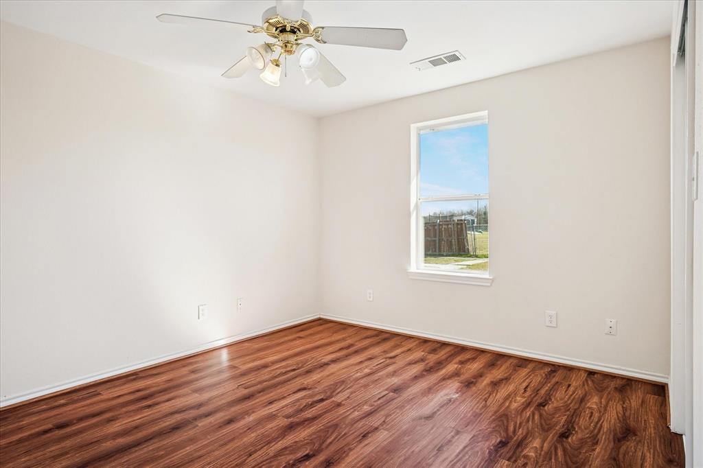 112 Sebastian Lane Josephine, TX 75173 - Photo 8 of 15 a view of an empty room with wooden floor and a window